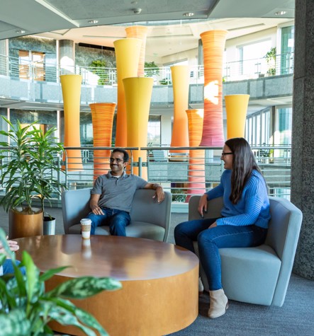 Two discover employees chatting in a modern office lounge  