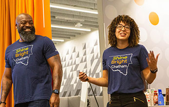 Two Smiling Team Members Wearing Chatham Shine Bright Tshirts