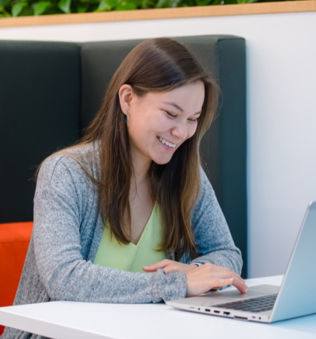 smiling young adult working on laptop
